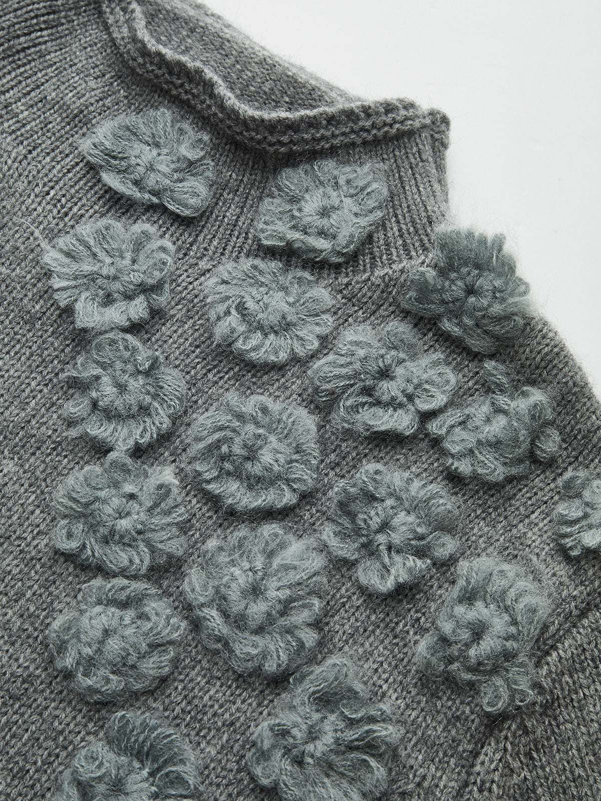 Sweter z ozdobnymi aplikacjami na ramieniu