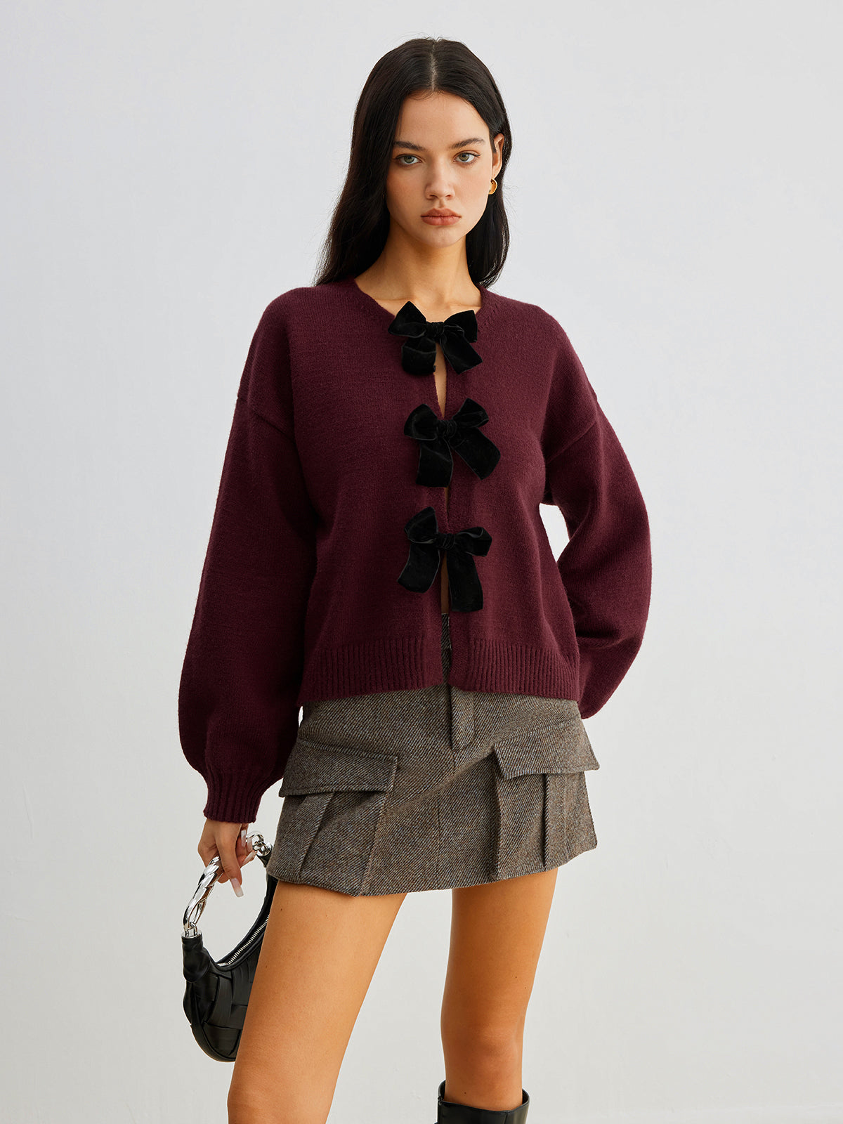 Sweter z ozdobnymi kokardkami na guziki